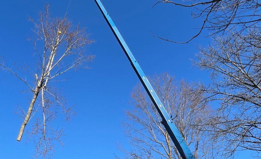 The Mathias Precision crane lifts a section of a tree over a house in St. Peters, MO.